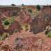 Ci basta per percorrere qualche metro per ammirare finalmente la cava principale, dallalto. Il paesaggio  ipnotico: le pareti rosse, valorizzate dal verde della vegetazione e arricchite dallazzurro del cielo, ci trasportano in un mondo visivamente inedito, dominato da unincantevole armonia cromatica